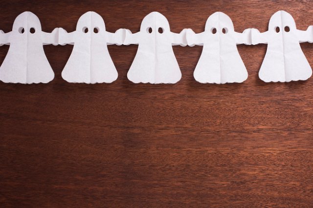 a line of five paper chain ghosts holding hands with space for text below