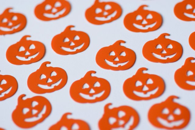 an array of orange plastic jack-o-lantern halloween decorations on white backgound