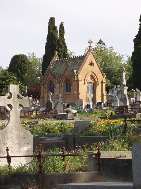 headstones and a small stone crypt in a cemetery