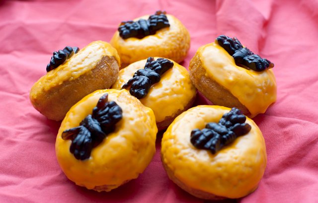 Orange sugar glazed Halloween doughnuts with spiders for a tasty fun trick or treat for the children during the festival