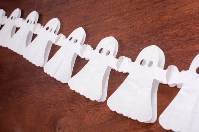 a row halloween ghost decorations on a wood backdrop