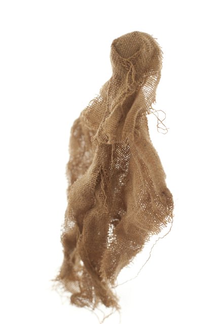 Torn pieces of burlap cloth wrinkled and partially tied up over isolated white background