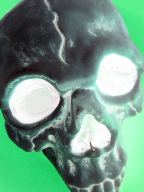 Eerie glowing x-ray of a human skull on green for a Halloween card design or theme