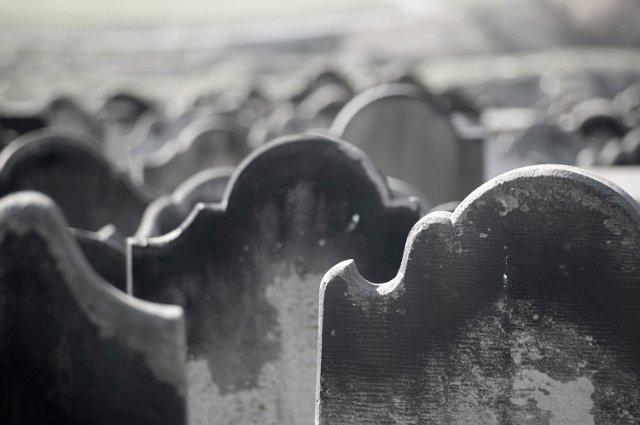 many rows of grim looking headstones in a cemetery