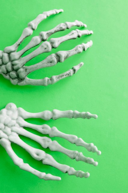 halloween skeleton hands on a green background