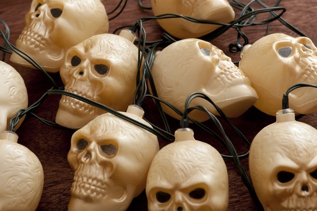 Angry plastic skull lanterns attached to one another by cord and placed carelessly on table
